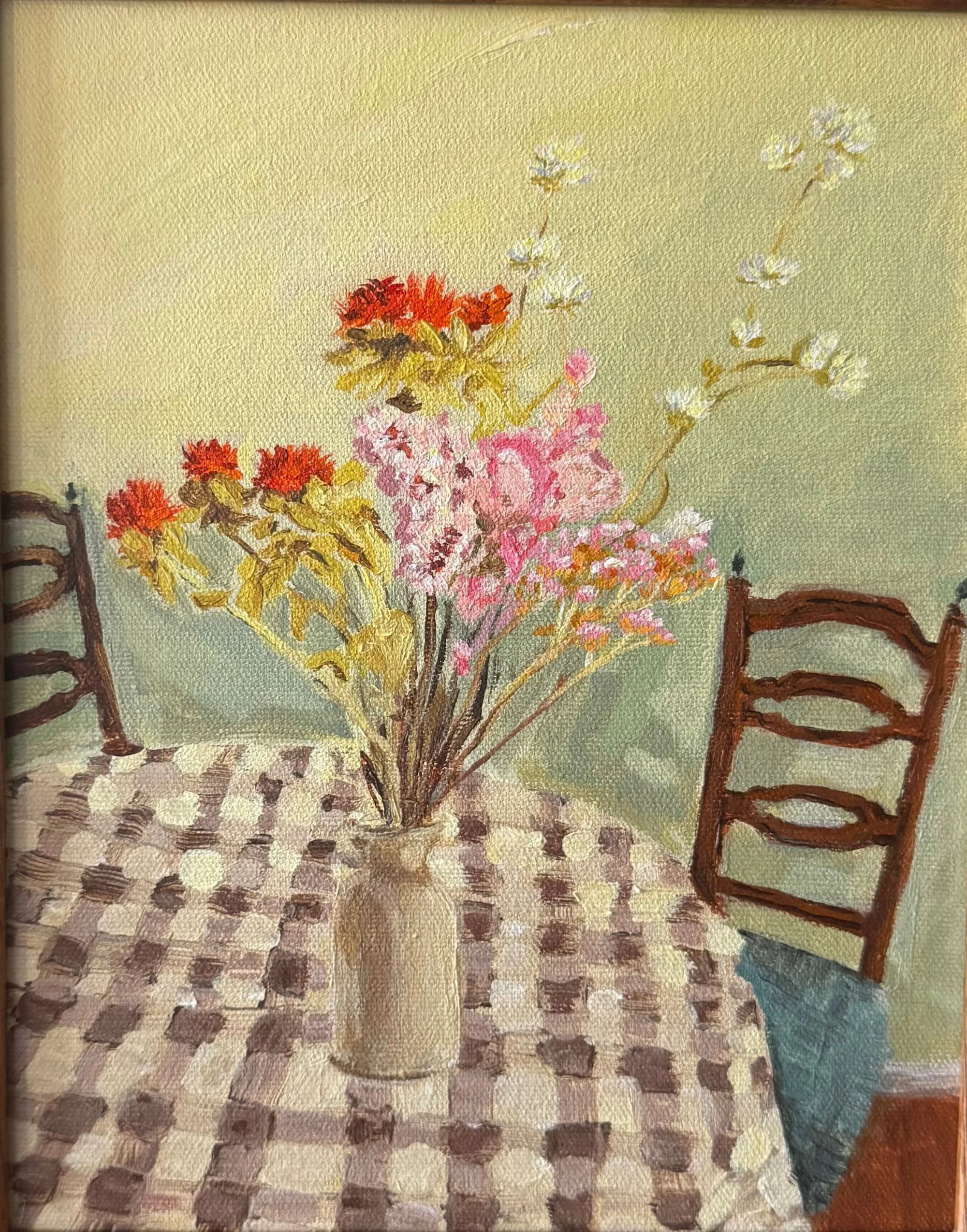 Still life painting of flowers in a vase on a checkered tablecloth with wooden chairs